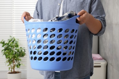 Man with basket full of laundry in bathroom, closeup