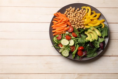 Photo of Balanced diet and vegetarian foods. Plate with different delicious products on wooden table, top view. Space for text