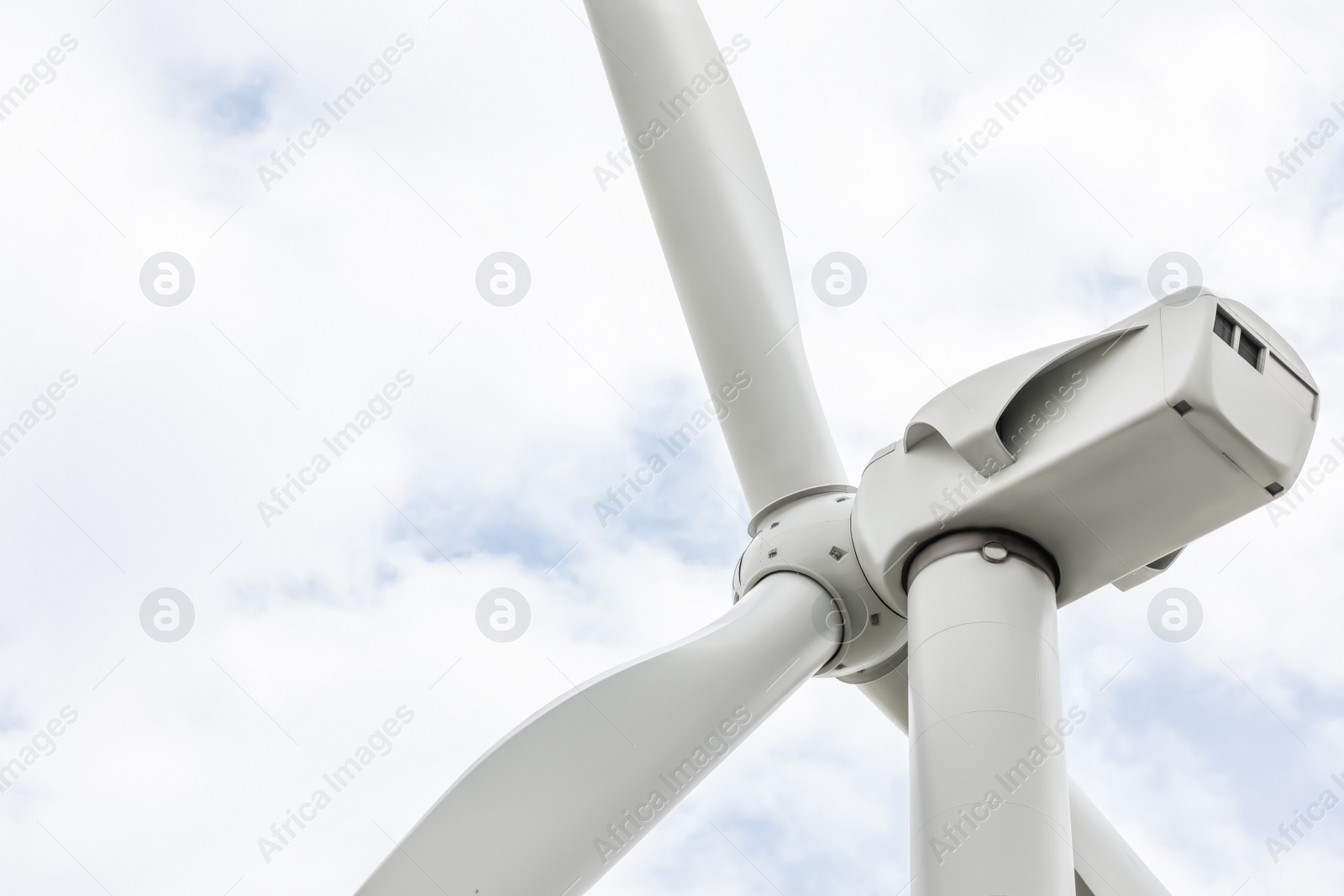 Photo of Modern wind turbine against cloudy sky, closeup. Alternative energy source