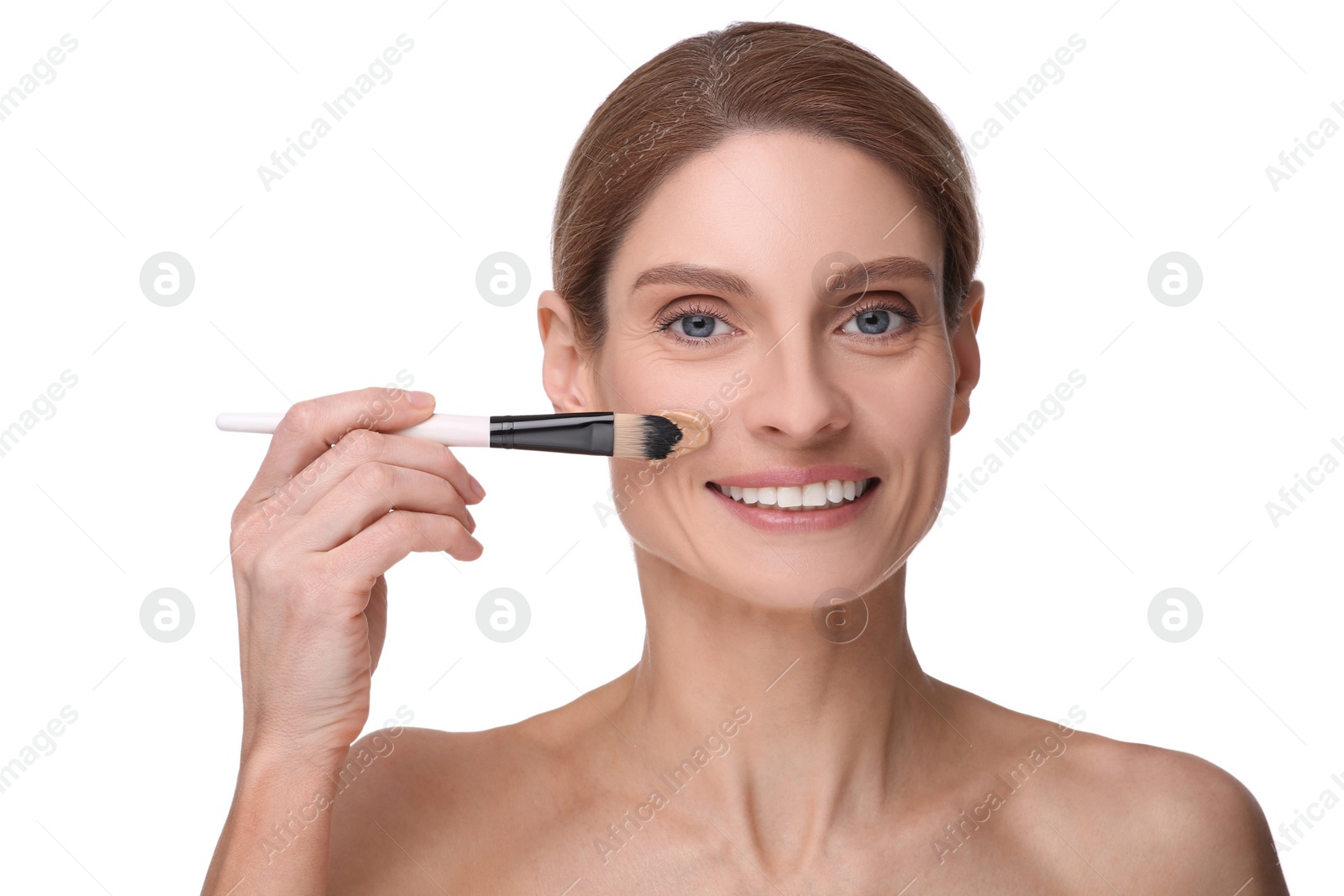 Photo of Woman applying foundation on face with brush against white background