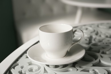 Empty cup with saucer on white table indoors, closeup