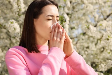 Photo of Woman with napkin suffering from seasonal allergy on spring day