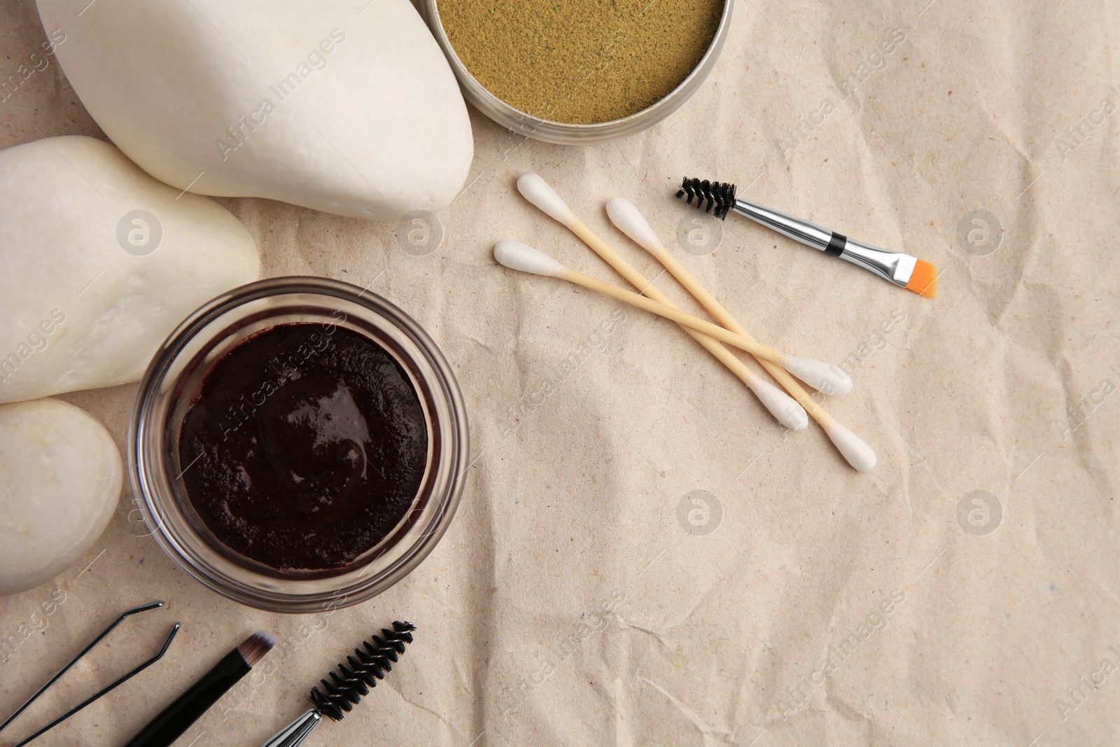 Photo of Flat lay composition with eyebrow henna and tools on crumpled paper. Space for text