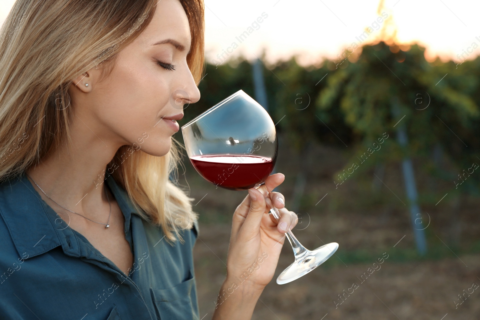 Photo of Young beautiful woman enjoying wine at vineyard