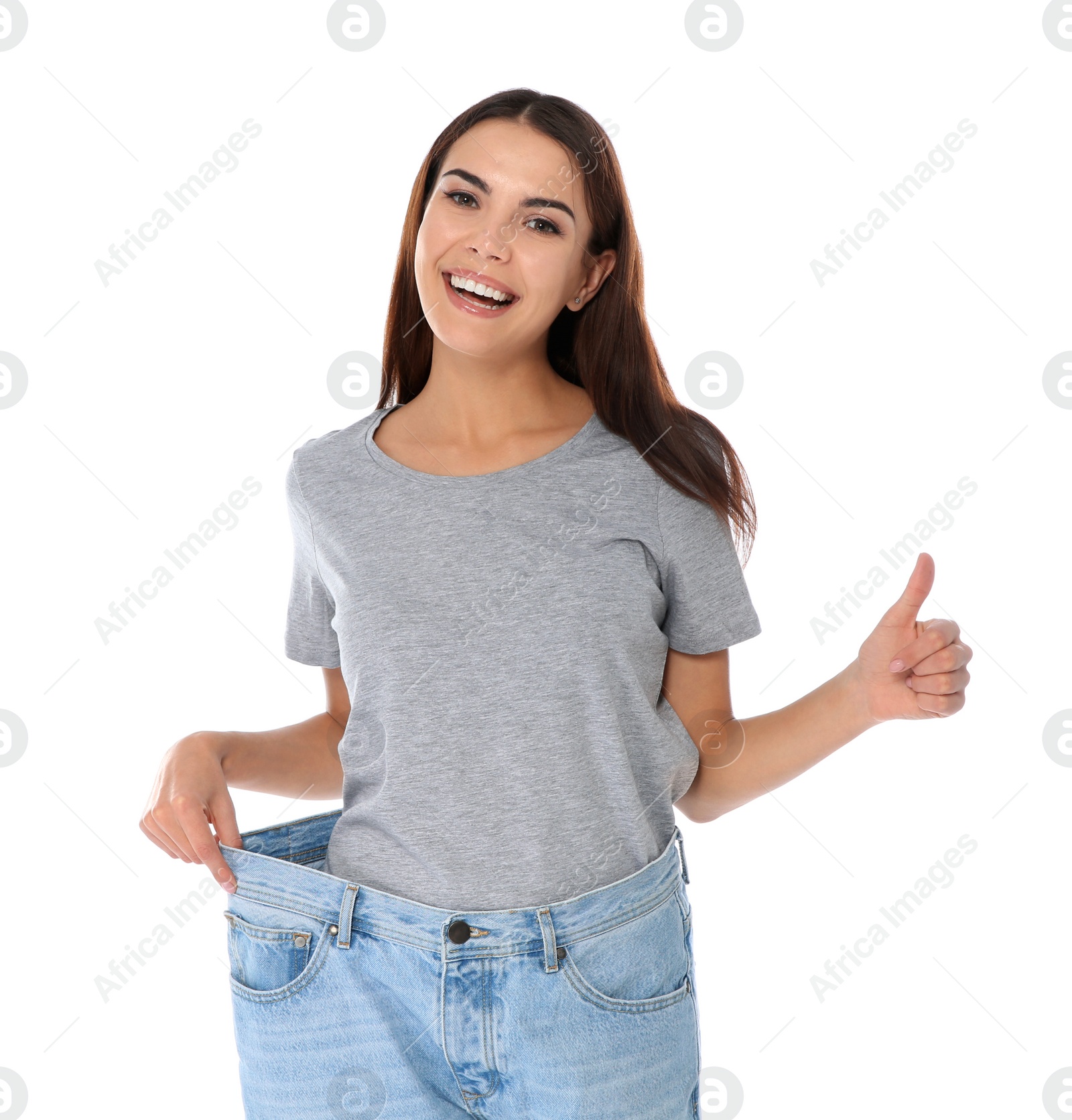 Photo of Slim woman in oversized jeans on white background. Weight loss