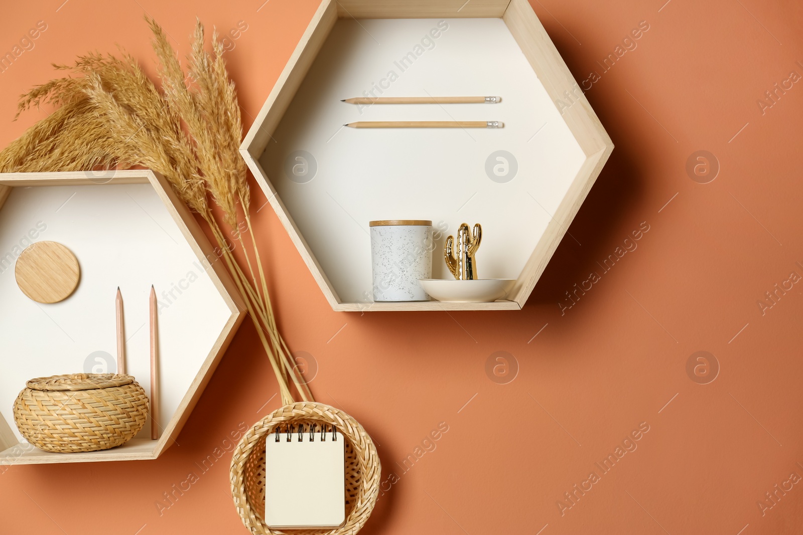 Photo of Shelves with stylish decorations on brown wall. Interior design