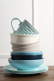 Photo of Beautiful ceramic dishware and cup on wooden table