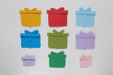 Photo of Colorful paper gift boxes on white background, flat lay