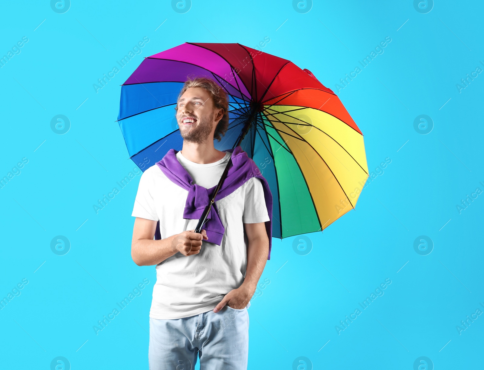 Photo of Man with rainbow umbrella on color background