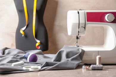 Photo of Sewing machine, fabric and accessories for tailoring on table