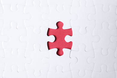 Photo of Blank white puzzle with missing piece on red background, top view