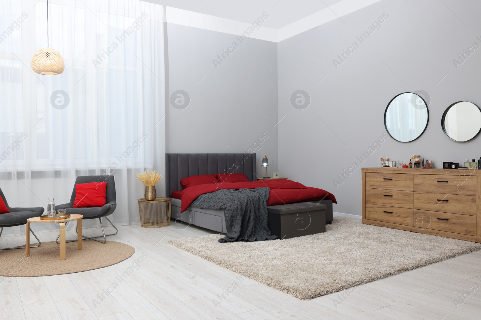 Photo of Stylish bedroom with comfortable bed and wooden chest of drawers. Interior design