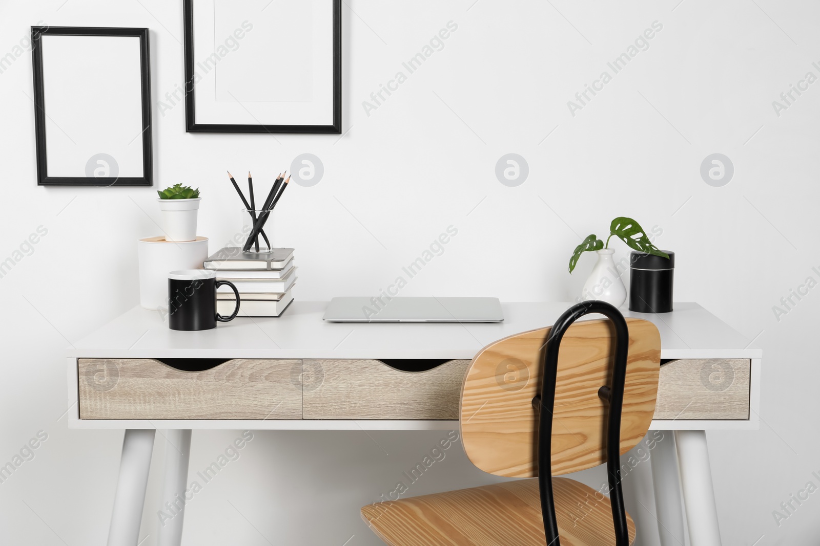 Photo of Home workplace. Laptop, stationery and houseplants on white wooden desk