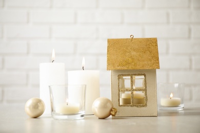 Composition with house shaped candle holder on light table. Christmas decoration