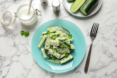 Photo of Plate with delicious cucumber salad served on marble table, top view