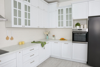 Photo of Modern kitchen interior with stylish white furniture