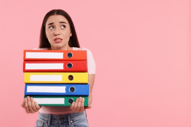 Photo of Frustrated woman with folders on pink background, space for text