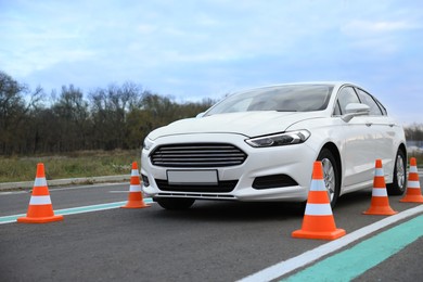 Photo of Modern car on test track with traffic cones. Driving school