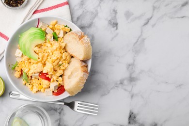 Photo of Delicious scrambled eggs, tofu, avocado and slices of baguette served on white marble table, flat lay. Space for text