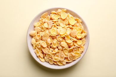 Photo of Bowl of tasty crispy corn flakes on light background, top view