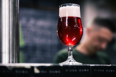 Glass of beer on bar counter in pub