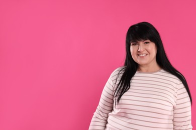 Photo of Beautiful overweight mature woman with charming smile on pink background. Space for text