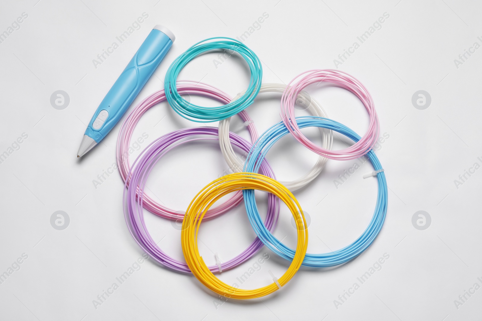 Photo of Stylish 3D pen and colorful plastic filaments on white background, flat lay