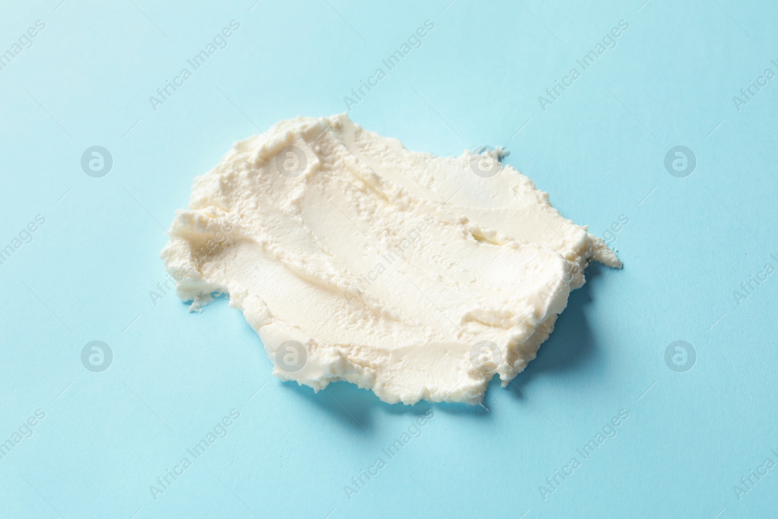 Photo of Smear of tasty cream cheese on color background