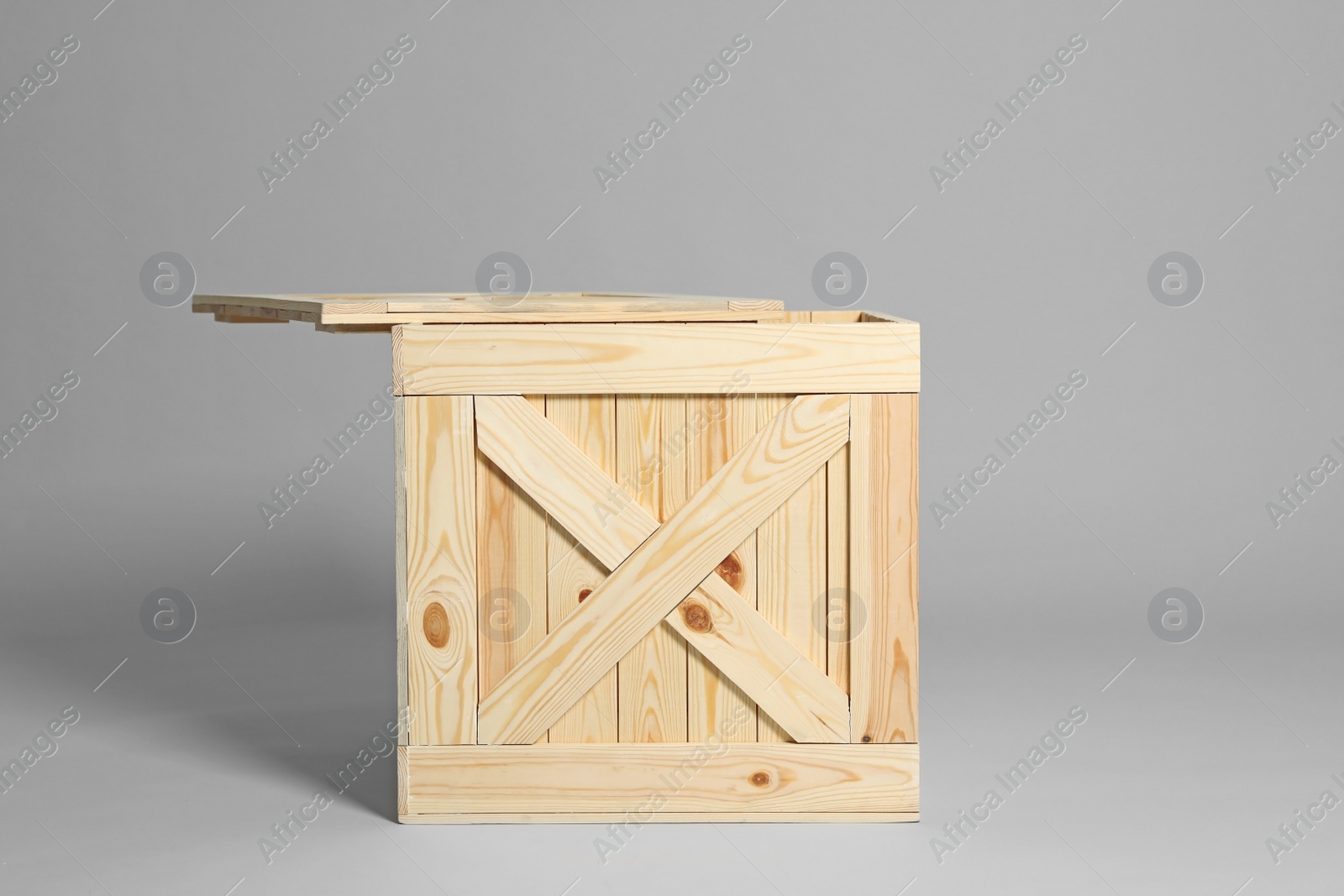 Photo of One open wooden crate on grey background