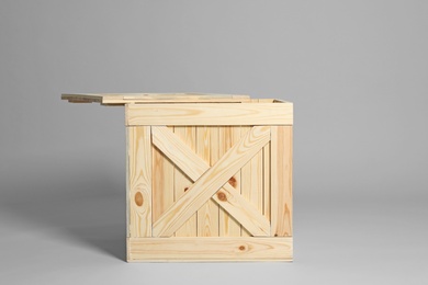 Photo of One open wooden crate on grey background