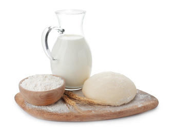 Photo of Board with dough, milk and flour on white background. Cooking pastries