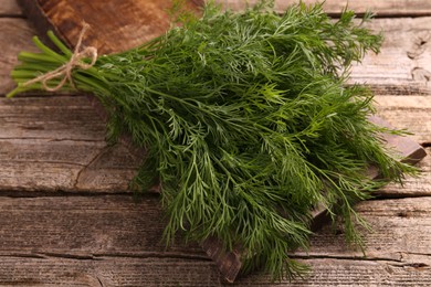 Photo of Bunch of fresh dill on wooden table, closeup