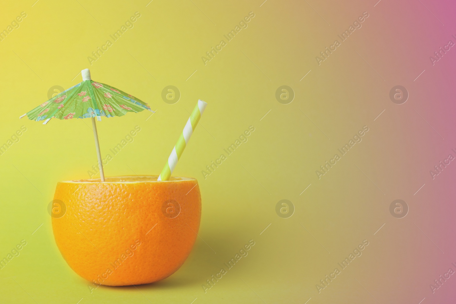 Image of Orange with straw and small paper umbrella on color background, space for text. Summer party