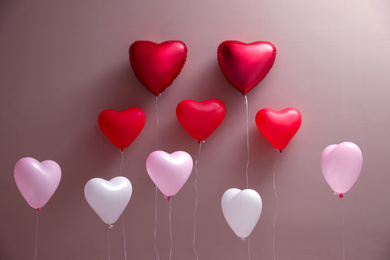 Photo of Colorful heart shaped balloons on brown background. Valentine's day celebration