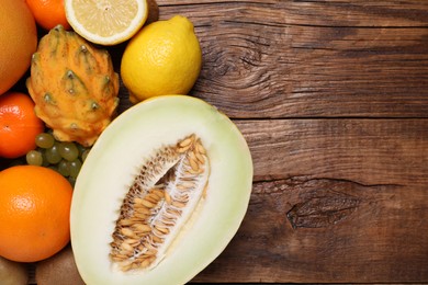 Photo of Many different fresh fruits on wooden table, flat lay. Space for text