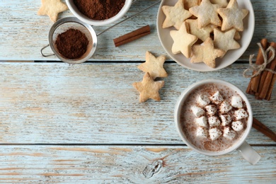 Photo of Composition with delicious hot cocoa drink and cookies on light blue wooden background, flat lay