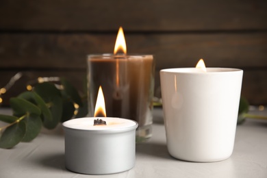 Photo of Burning scented candles on light grey table