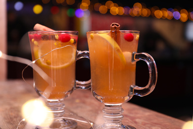 Photo of Tasty aromatic mulled wine on wooden table