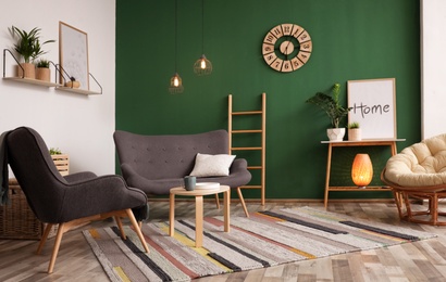 Photo of Modern living room interior stylish sofa near green wall