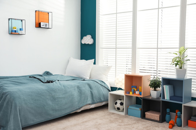 Photo of Modern child room interior with comfortable bed near window