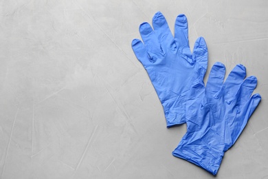 Photo of Pair of medical gloves on light grey background, flat lay. Space for text