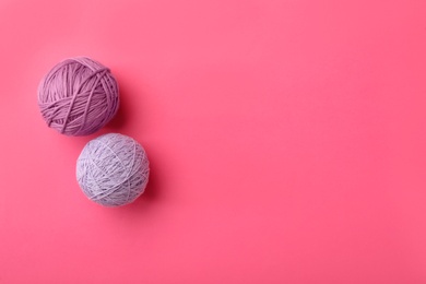Photo of Soft colorful woolen yarns on pink background, flat lay. Space for text