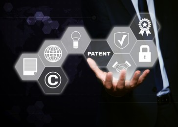 Image of Patent concept. Different virtual icons and man on dark background, closeup