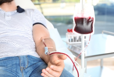 Photo of Man making blood donation at hospital, closeup