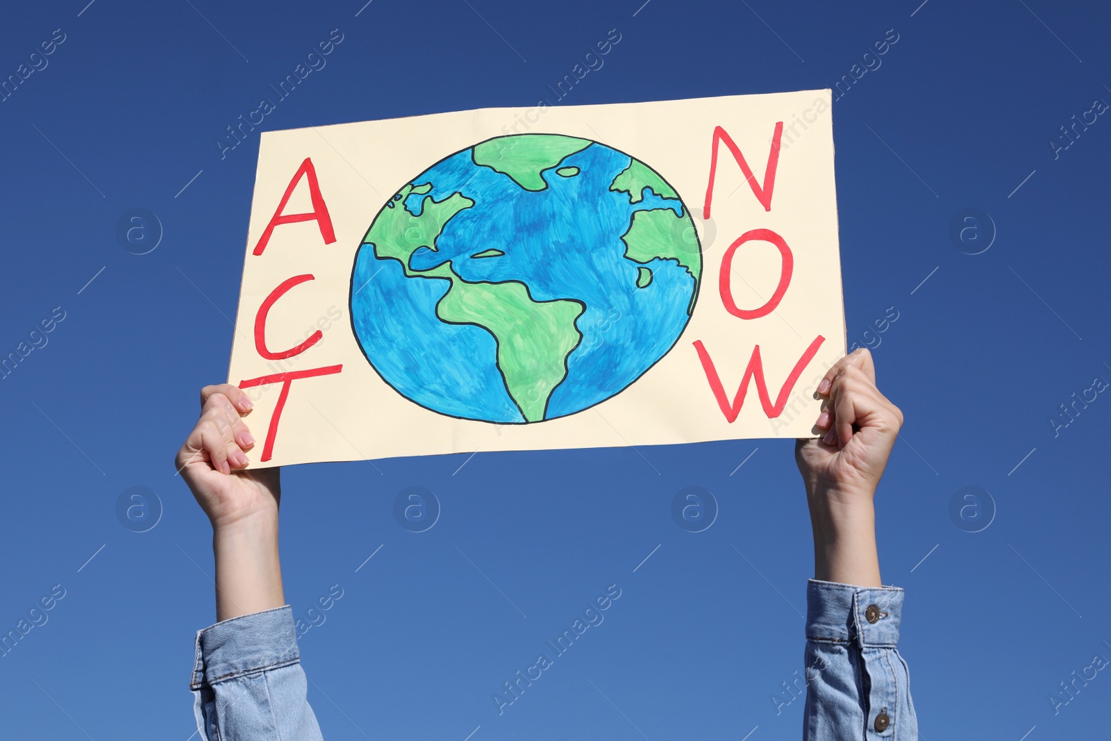 Photo of Young woman with poster protesting against climate change outdoors, closeup