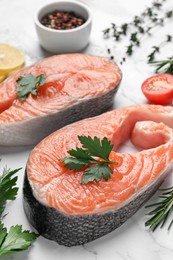 Photo of Fresh salmon and ingredients for marinade on white marble table