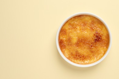 Photo of Delicious creme brulee on beige background, top view. Space for text