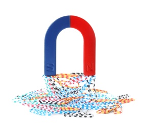 Photo of Magnet attracting paper clips on white background