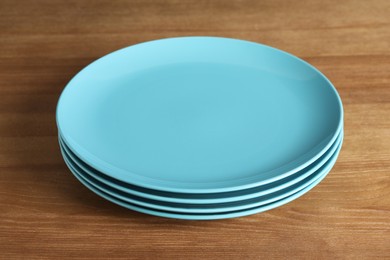 Photo of Elegant new empty plates on wooden table
