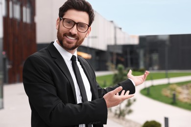 Photo of Handsome real estate agent outdoors. Space for text